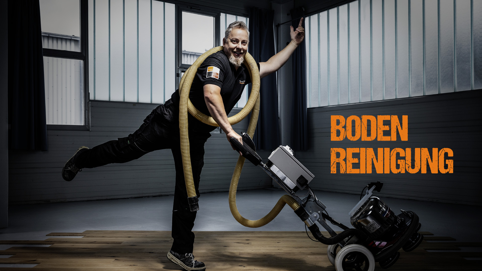 Ronny Schulz von RS Bodentechnik, der Bodenkavalier tanzt mit einer Maschine über den Parkettboden. Ein Schlauch ziert seinen Oberkörper.